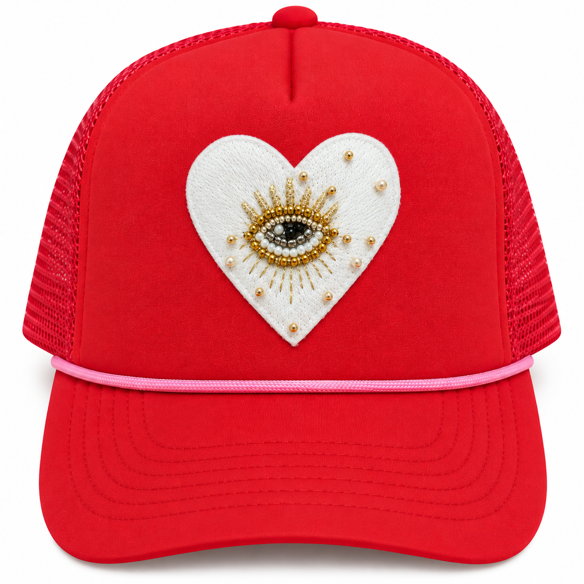 Front view of red trucker hat with white heart patch, beaded evil eye, gold-tone accents, and pink rope trim