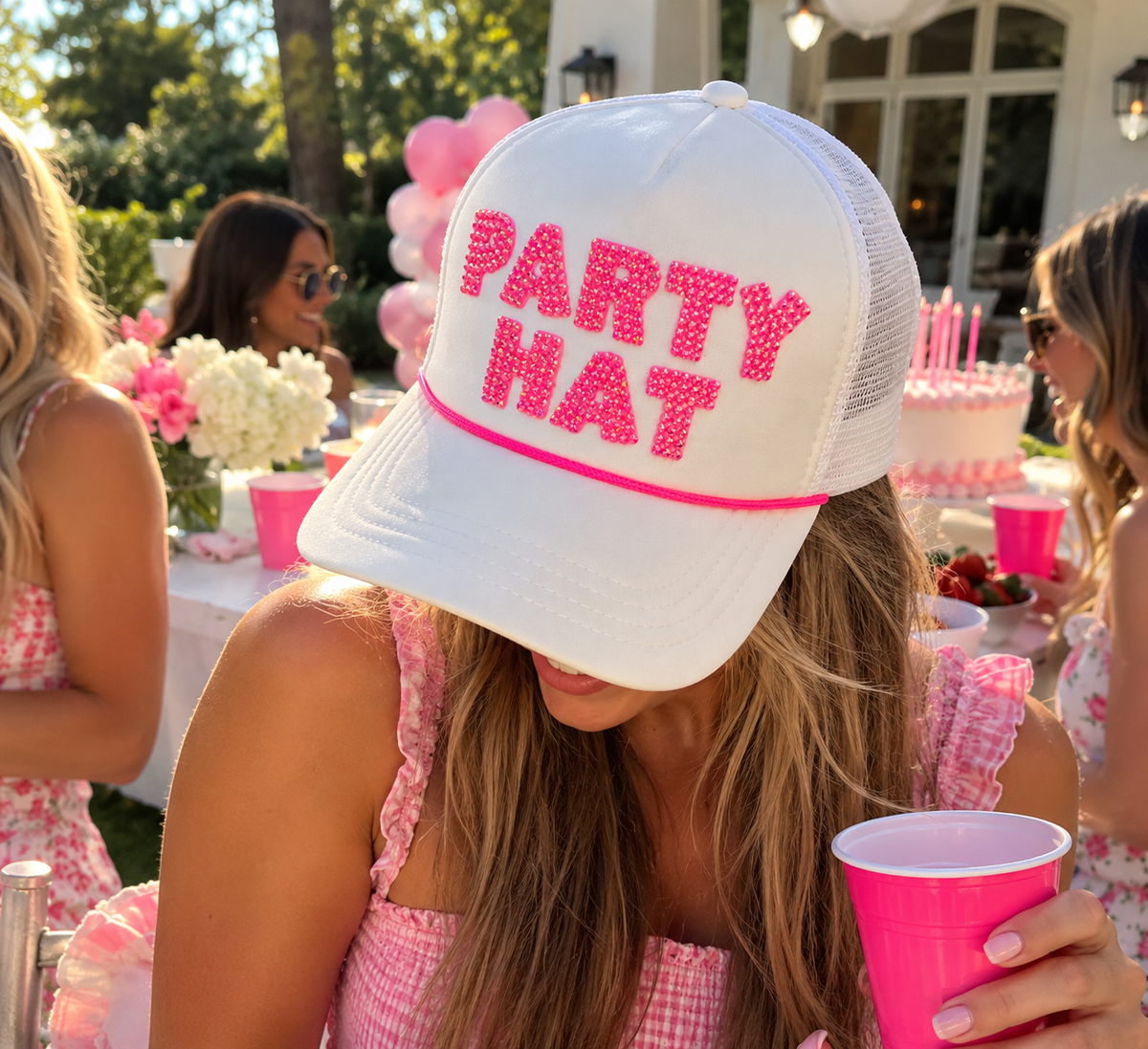 Woman wearing white rhinestone PARTY HAT trucker hat at a birthday party